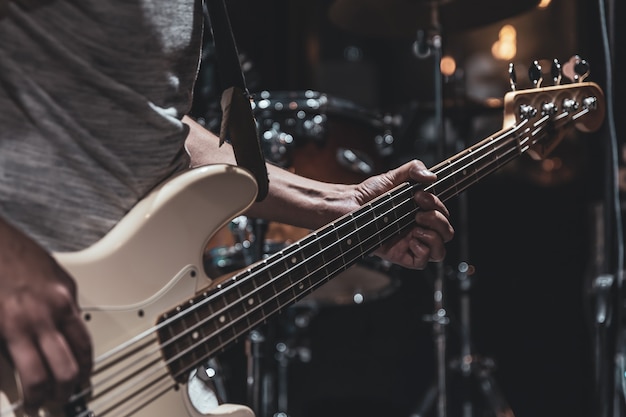 Bliska gitara basowa na niewyraźne ciemne tło kopii przestrzeni.