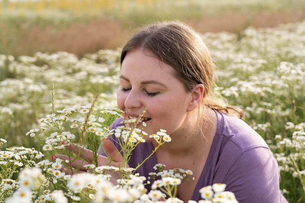 Bezpłatne zdjęcie bliska kobieta pachnąca kwiaty
