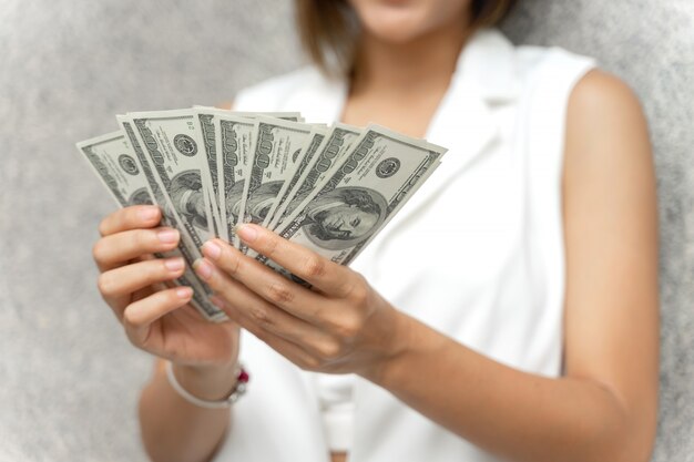 bliska kobieta trzyma w ręku rachunki w dolarach amerykańskich