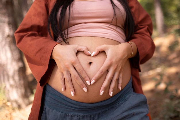 Bezpłatne zdjęcie bliska kobieta w ciąży na zewnątrz