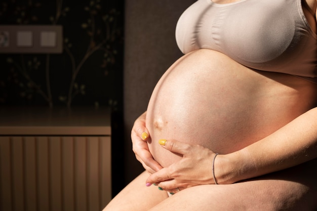 Bliska kobieta w ciąży trzymająca brzuch
