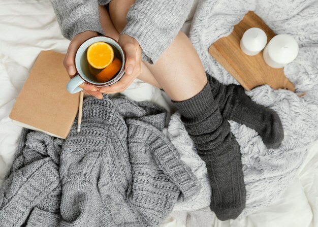 Bliska kobieta w łóżku pije herbatę