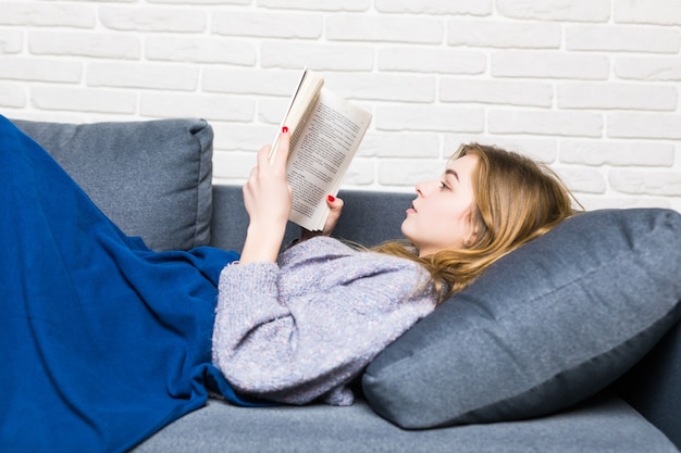 Bezpłatne zdjęcie bliska leżącego nastolatka czytanie książki relaks w domu