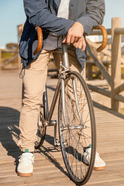 Bezpłatne zdjęcie bliska mężczyzna pozowanie z rowerem