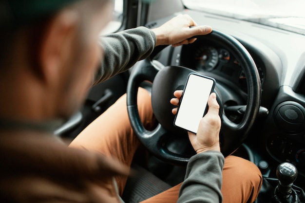 Bliska mężczyzna w samochodzie z telefonem komórkowym