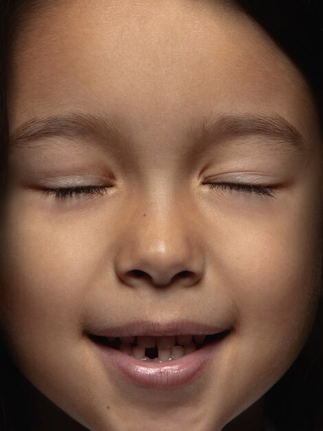 Bezpłatne zdjęcie bliska portret dziewczynki azjatyckie małe i emocjonalne. bardzo szczegółowe zdjęcie modelki o zadbanej skórze i jasnym wyrazie twarzy. pojęcie ludzkich emocji. uśmiech z zamkniętymi oczami.