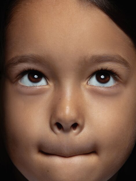 Bliska portret dziewczynki azjatyckie małe i emocjonalne. Bardzo szczegółowe zdjęcie modelki o zadbanej skórze i jasnym wyrazie twarzy. Pojęcie ludzkich emocji. Wątpliwości, niepewność, wybór.