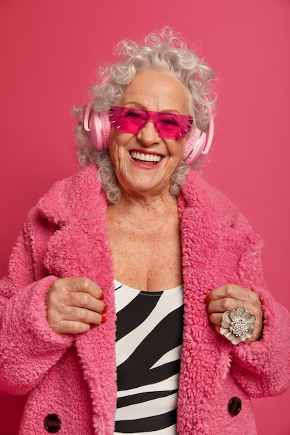 Bezpłatne zdjęcie bliska portret szczęśliwy pomarszczony modnej babci na sobie różowe rajstopy i płaszcz