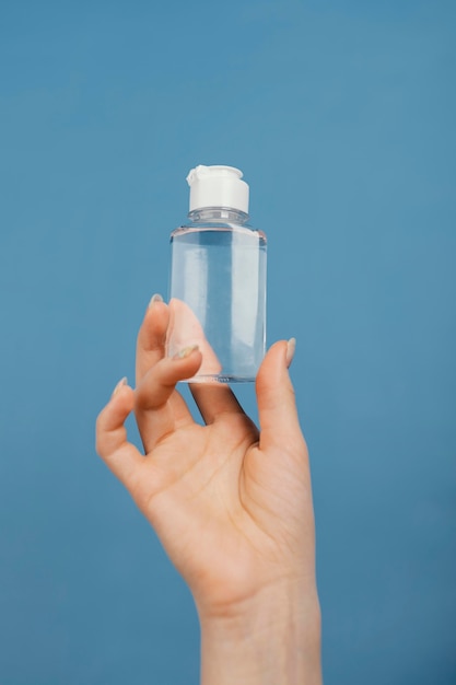 Bliska ręka z butelką do dezynfekcji rąk