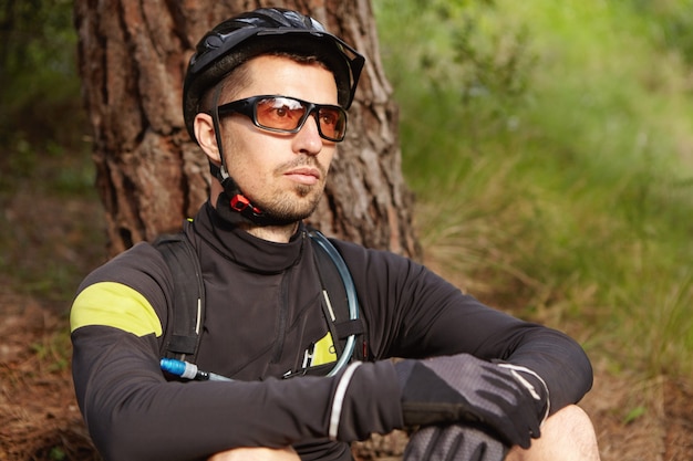 Bezpłatne zdjęcie bliska strzał przystojny rowerzysta z brodą relaks po treningu