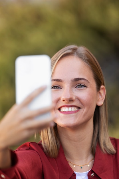 Bliska uśmiechnięta kobieta trzymająca telefon