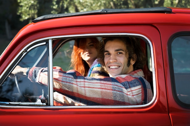Bezpłatne zdjęcie bliska uśmiechnięta para w czerwonym samochodzie