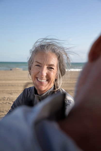 Bliska uśmiechnięta starsza kobieta na plaży