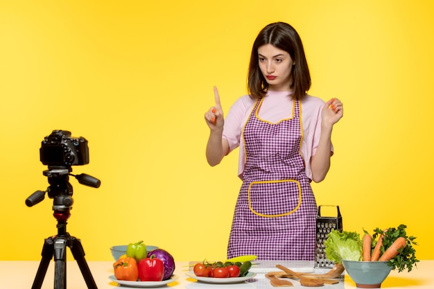 Blogerka Kulinarna ładna Młoda Dziewczyna W Różowym Fartuchu Z Nagraniem Wideo Wyjaśniającym W Aparacie