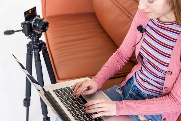 Blogger z wysokim widokiem siedzi na kanapie za pomocą swojego laptopa
