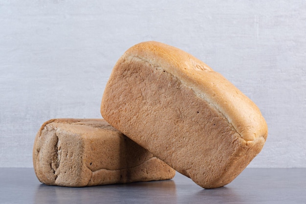 Bezpłatne zdjęcie bloki chleba ułożone na marmurowym tle. zdjęcie wysokiej jakości