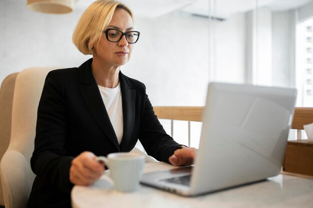 Blond kobieta biznesu pracuje na swoim laptopie