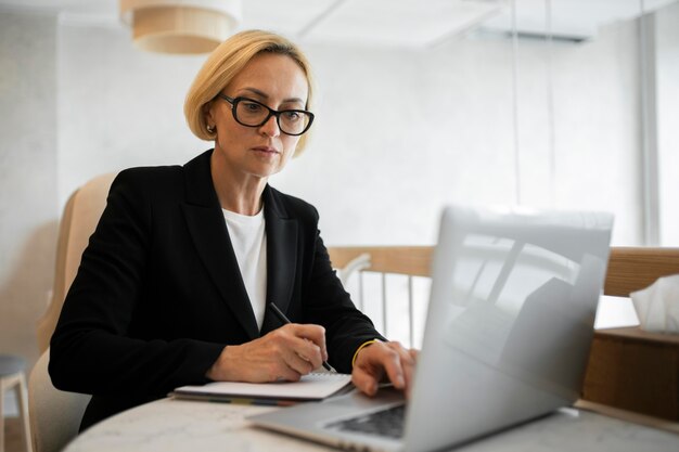 Blond kobieta biznesu pracuje na swoim laptopie