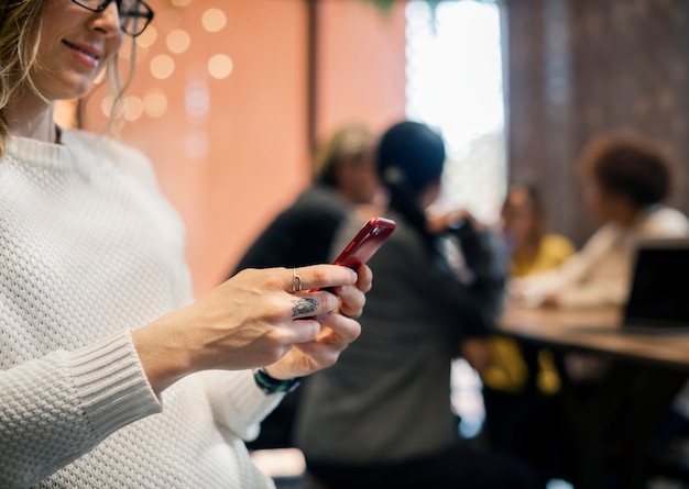 Bezpłatne zdjęcie blond kobieta texting na jej telefonie