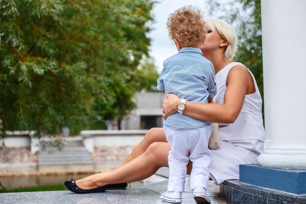 Blond kobieta w białej sukni i jej śliczne małe dziecko.