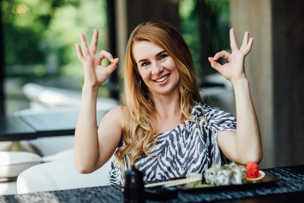 Bezpłatne zdjęcie blondynka spędza czas na sushi w restauracji