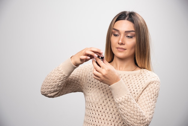 Blondynka sprawdza zdjęcia na folii polaroid i czuje się zawiedziona