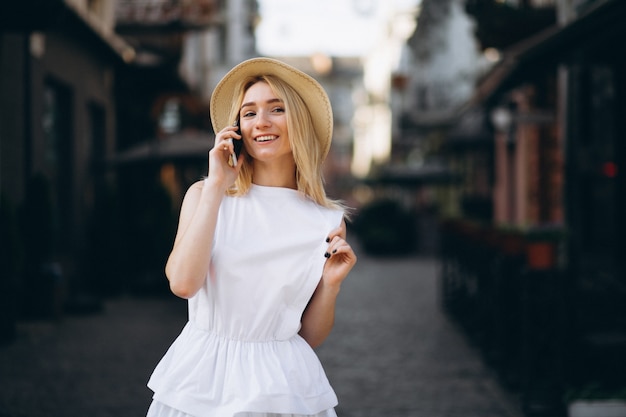 Bezpłatne zdjęcie blondynki kobieta w kapeluszowym używa telefonie