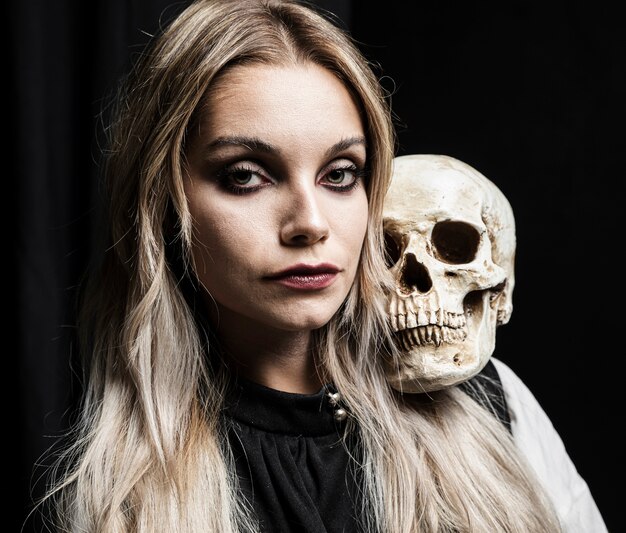 Blondynki kobiety mienia czaszka na ramieniu