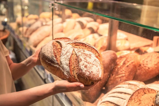 Bezpłatne zdjęcie bochenek chleba w rękach kobiet w supermarkecie