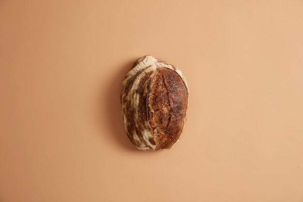 Bezpłatne zdjęcie bochenek chleba wykonany z ekologicznych składników pełnoziarnistych, gryczanych, żytnich i bez drożdży. pieczywo wieloziarniste na beżowym tle. koncepcja zdrowej żywności i odżywiania. świeżość pieczenia każdego dnia