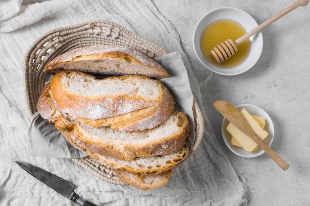 Bezpłatne zdjęcie bochenki chleba w koszu z masłem i miodem
