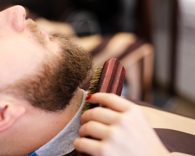 Bocznego widoku klient ma jego brody przygotowywającego zakończenie