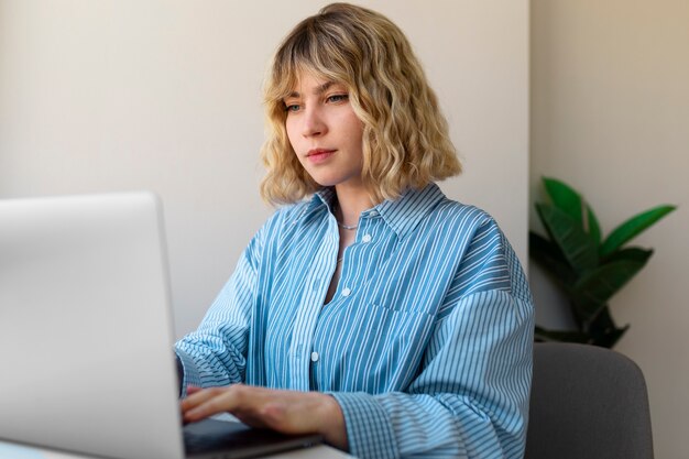 Bocznego widoku kobieta pracuje na laptopie