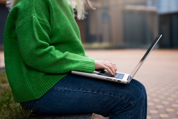 Bocznego widoku kobieta pracuje na laptopie