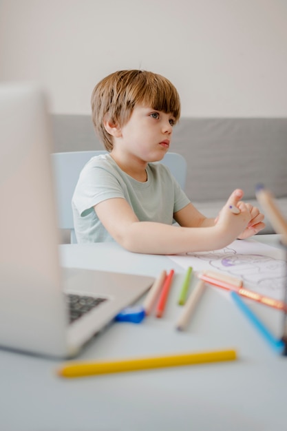 Boczny widok dziecko uczy w domu z laptopem w domu