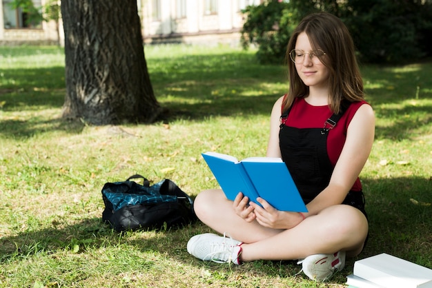 Boczny widok highschool dziewczyny czytelnicza książka