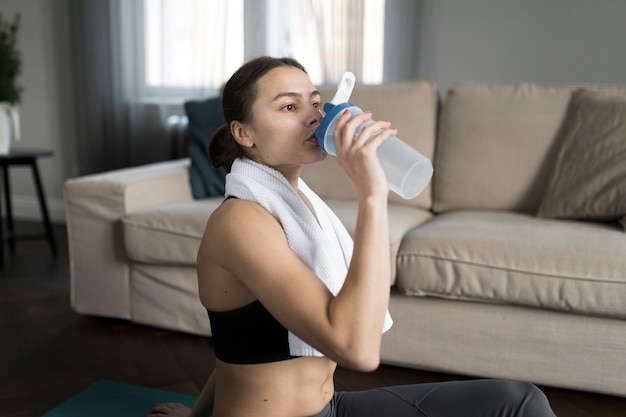 Bezpłatne zdjęcie boczny widok kobiety woda pitna po ćwiczyć