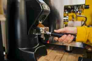 Bezpłatne zdjęcie boczny widok robi kawie przy kawową maszyną barista