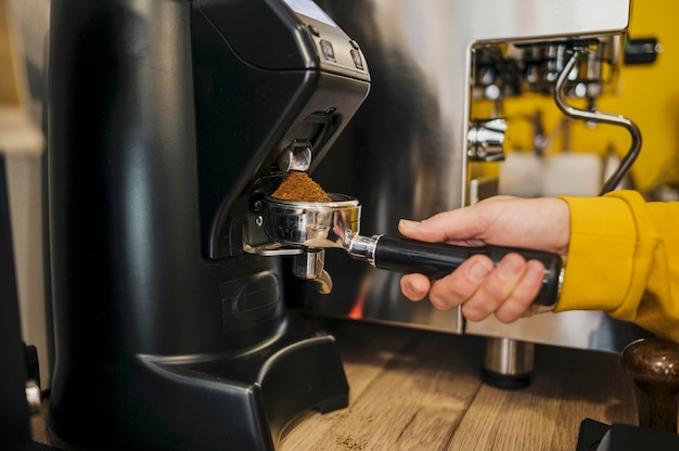 Boczny widok robi kawie przy kawową maszyną barista