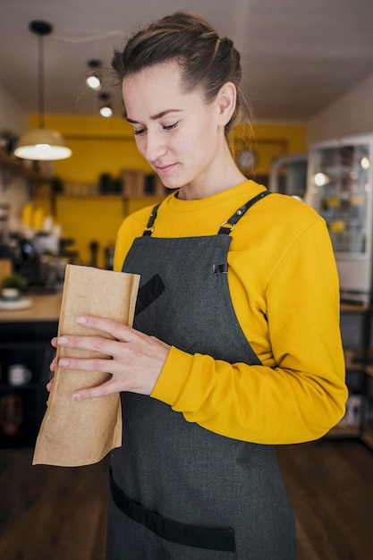 Boczny widok trzyma kawową paczkę barista