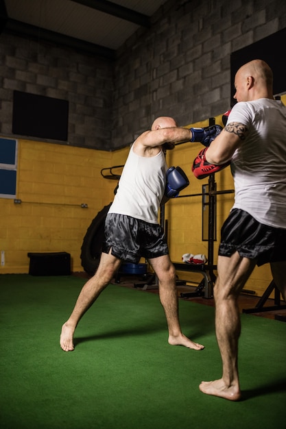 Bezpłatne zdjęcie bokserzy ćwiczący boks w studio fitness