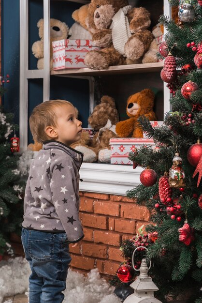 Bożenarodzeniowy pojęcie z dzieciakiem patrzeje choinki