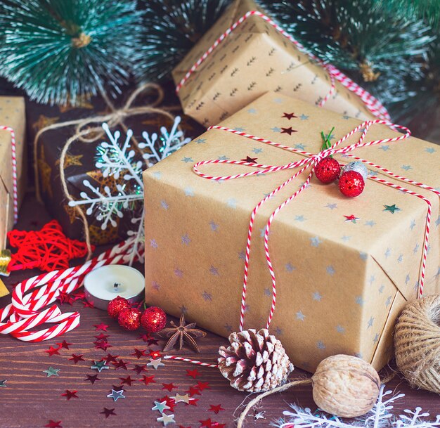 Bożenarodzeniowy wakacyjny prezenta pudełko na dekorującym śnieżnym świątecznym stole z sosnowymi rożkami jedlinowymi gałąź