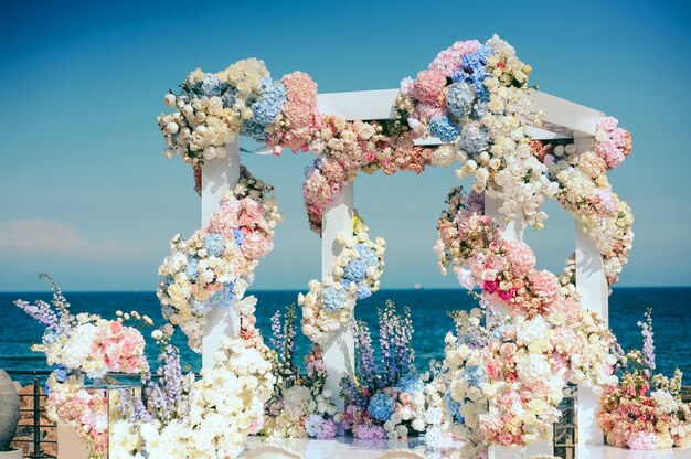 Brama ślubna z dużą ilością różnych kwiatów