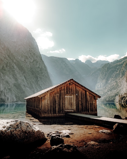 Brązowy drewniany dom w pobliżu jeziora i góry w ciągu dnia