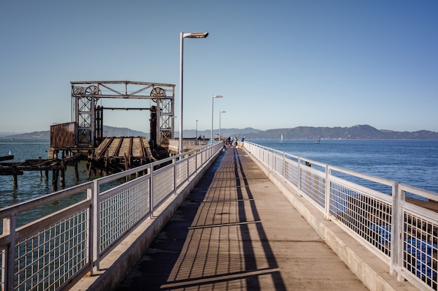 Brązowy drewniany most nad błękitne morze pod błękitnym niebem w ciągu dnia