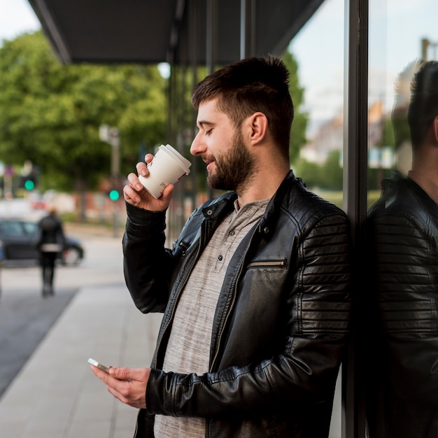 Brodaty Mężczyzna Pije Od Filiżanki I Używa Smartphone