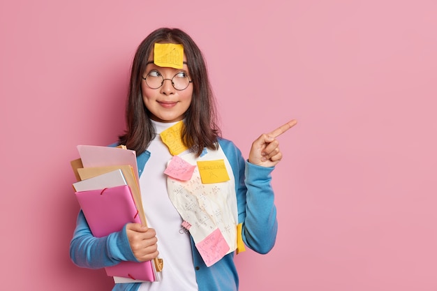 brunetka azjatycka kobieta menedżer bada dokumenty papierowe wskazuje na puste miejsce działa na projekt startowy.