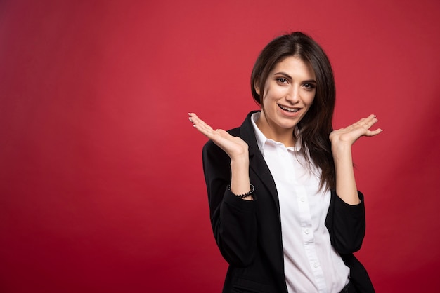 Brunetka Bizneswoman Stojąc Na Czerwonym Tle.