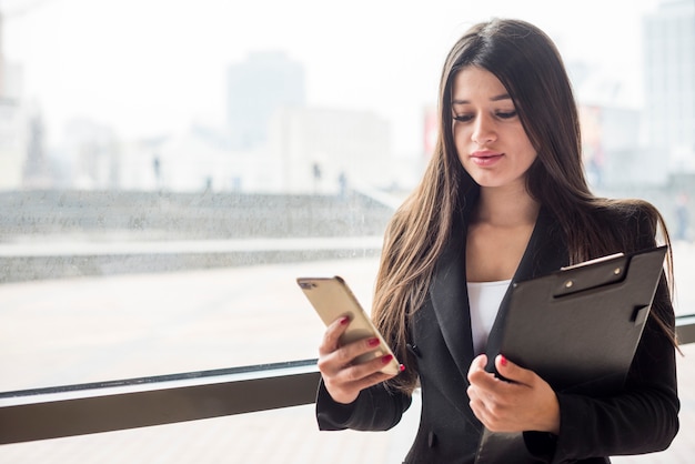 Brunetka bizneswoman używa jej telefon komórkowego